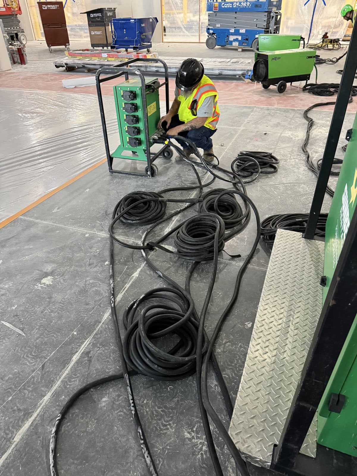 Temporary power distribution with a spider box and cable runs on an active job site