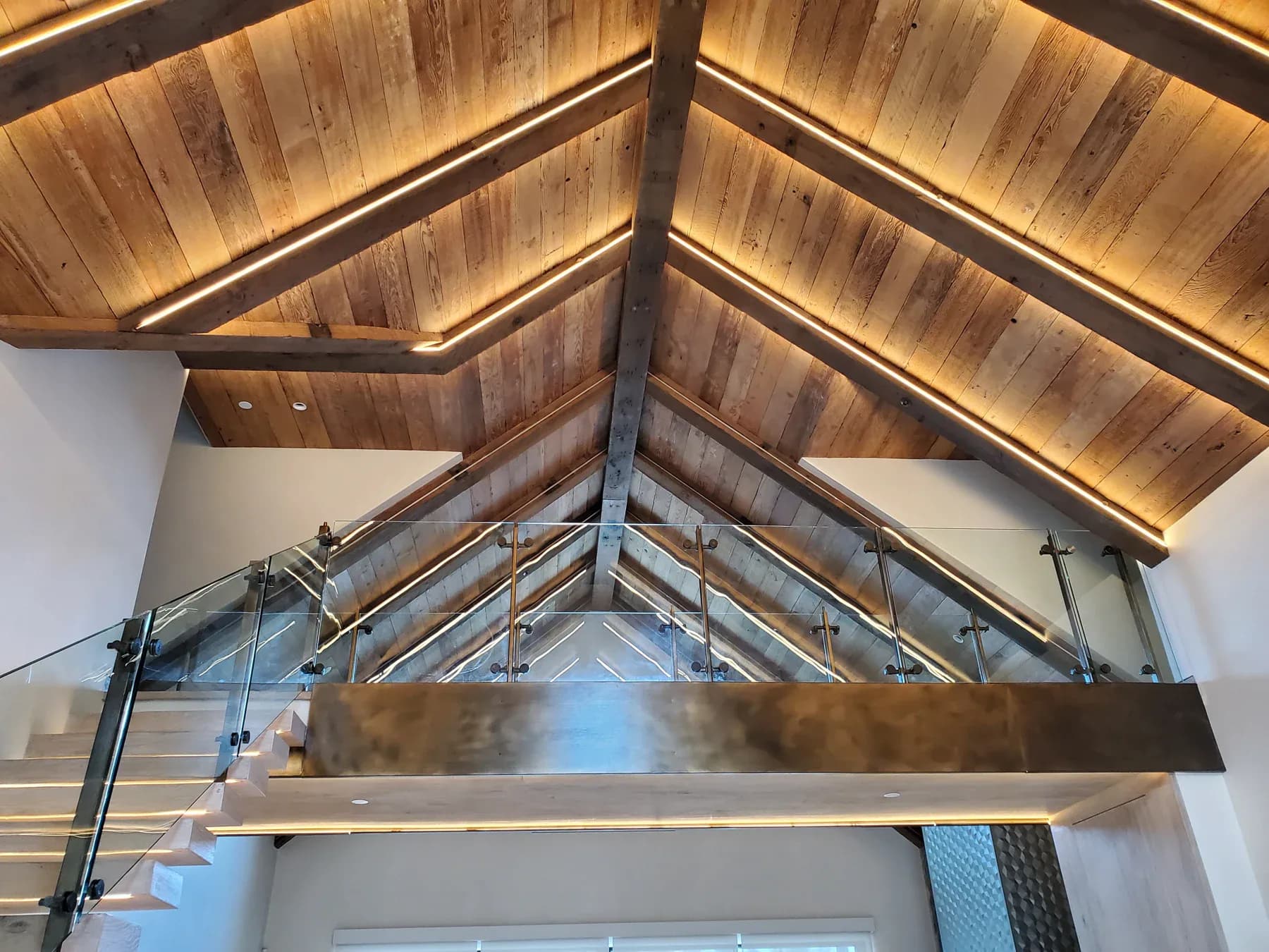 Warm concealed lighting following the timber beams of a vaulted ceiling