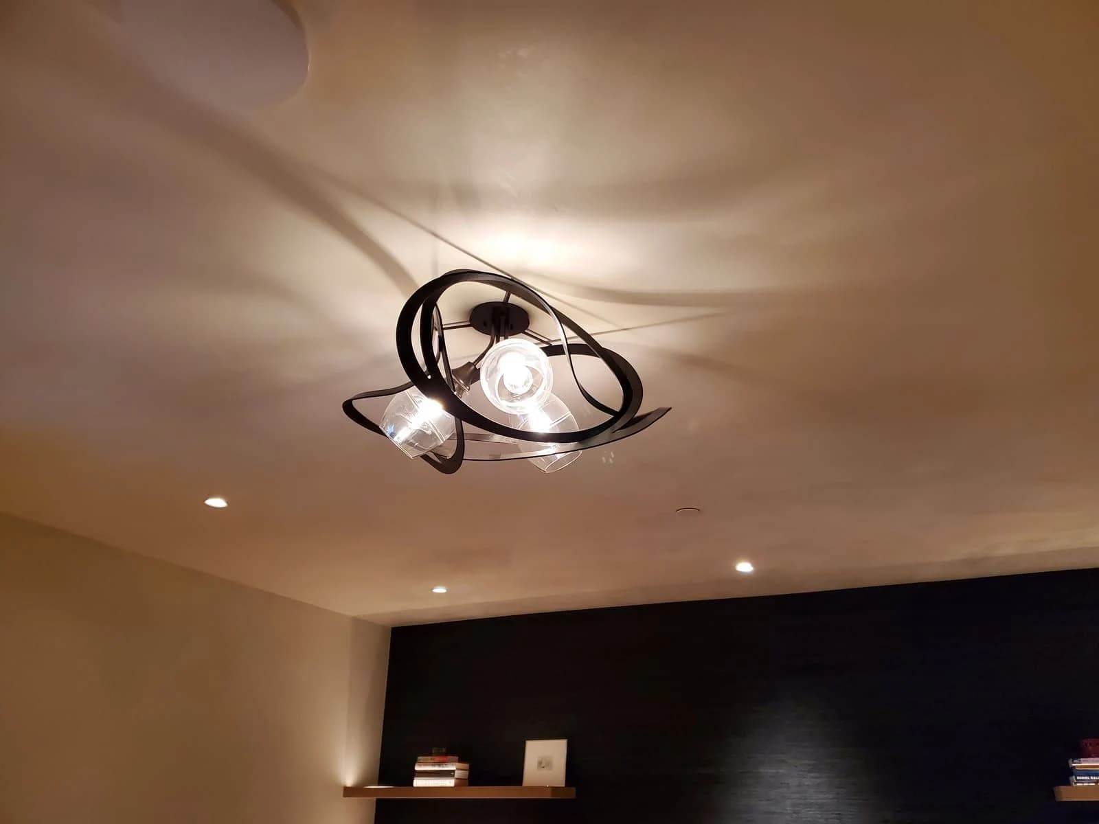 Sculptural ceiling fixture casting patterned light across the ceiling