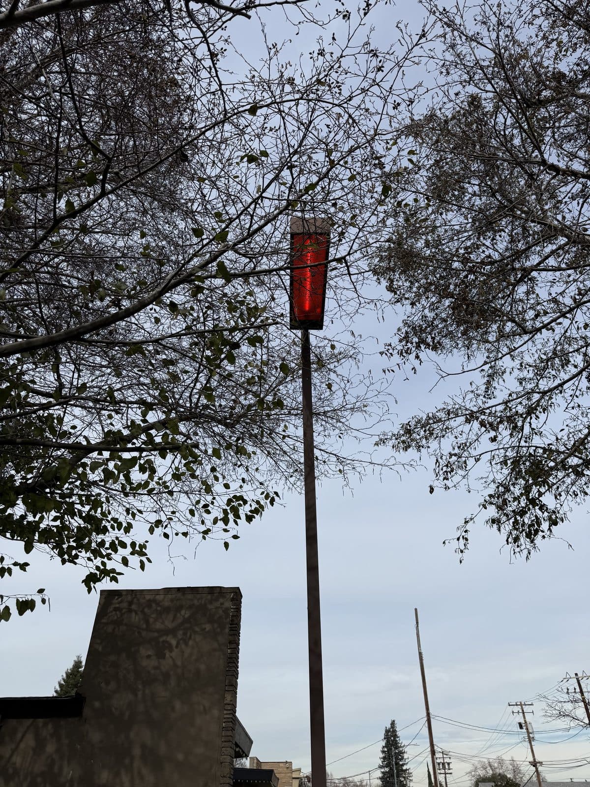 Pole light glowing dim red at the end of its HID lamp life