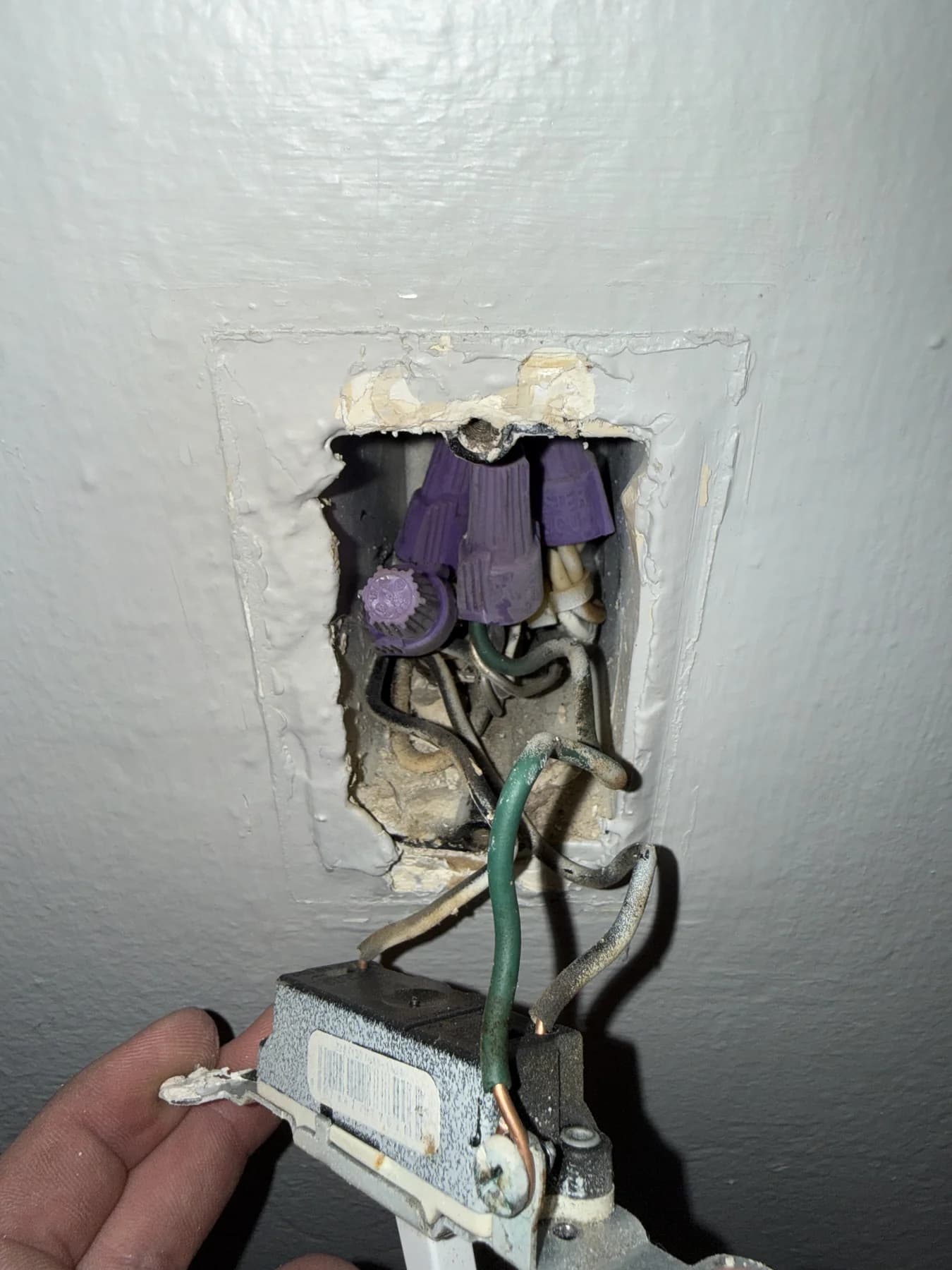Open switch box and removed switch with conductors visible