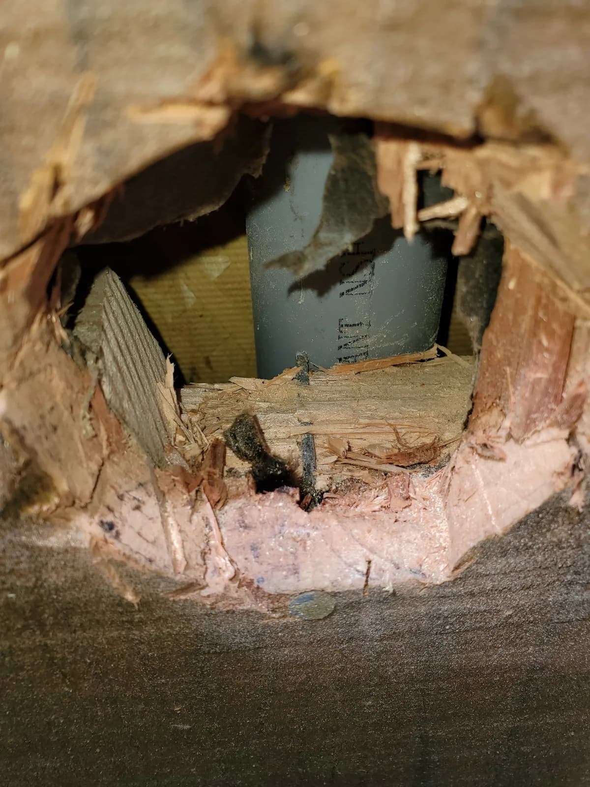 Opening in wall framing with pink insulation and gray cable visible