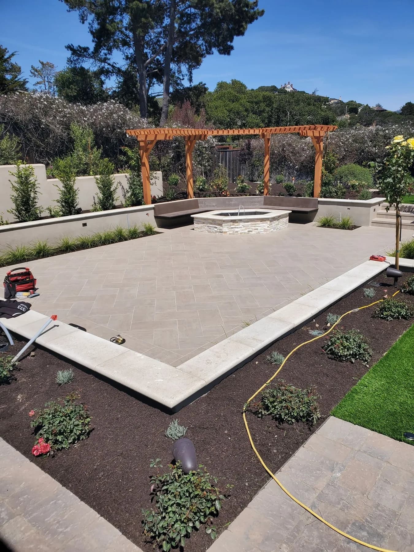 Real Carmel patio with recessed wall lights and a pergola, photographed in daylight